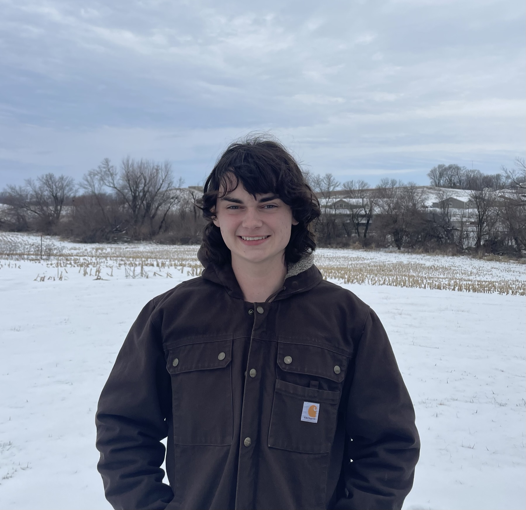 Ethan standing in a snowy cornfield.