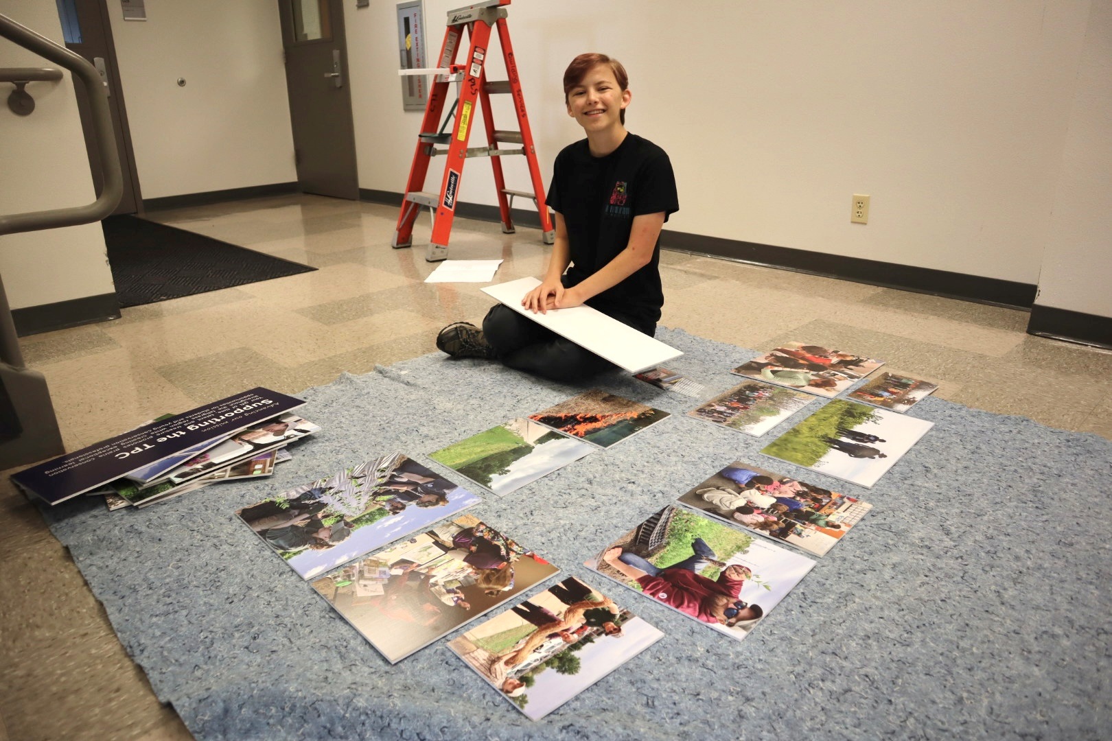 Molly seated in the TPC hallway working on the new hallway display. 