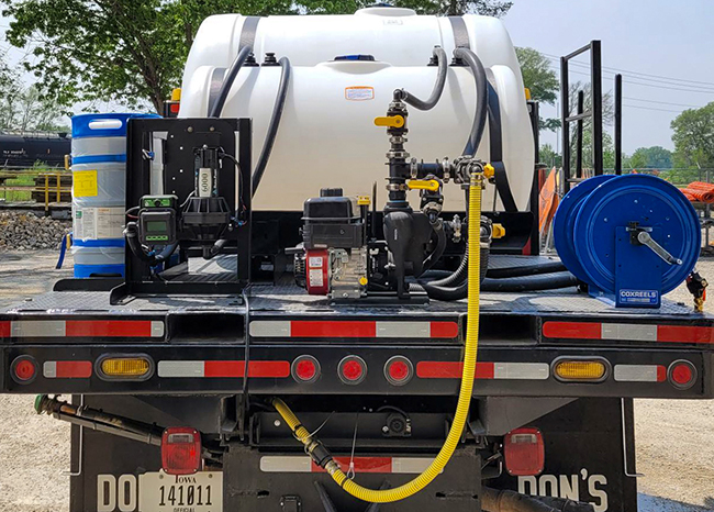 A spray system with large water tanks and other equipment mounted to the flatbed of a pickup truck.