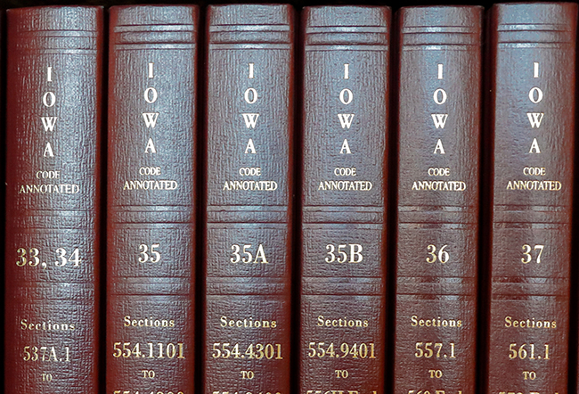 Three volumes of the bound version of the Iowa Code on a bookshelf.